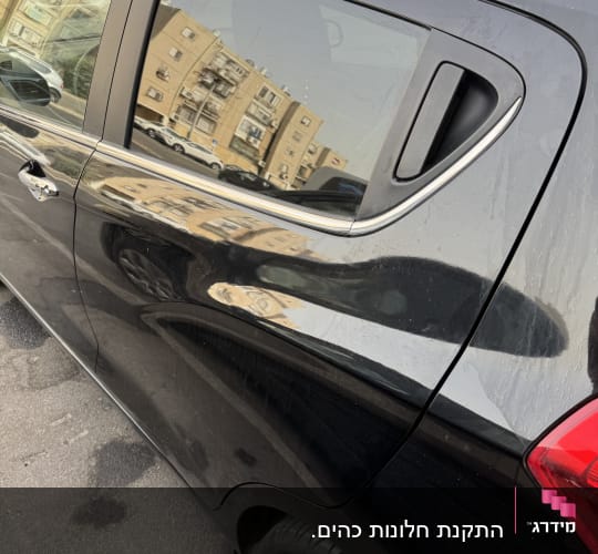 חלון רכב עם השתקפות בניינים בסביבה עירונית